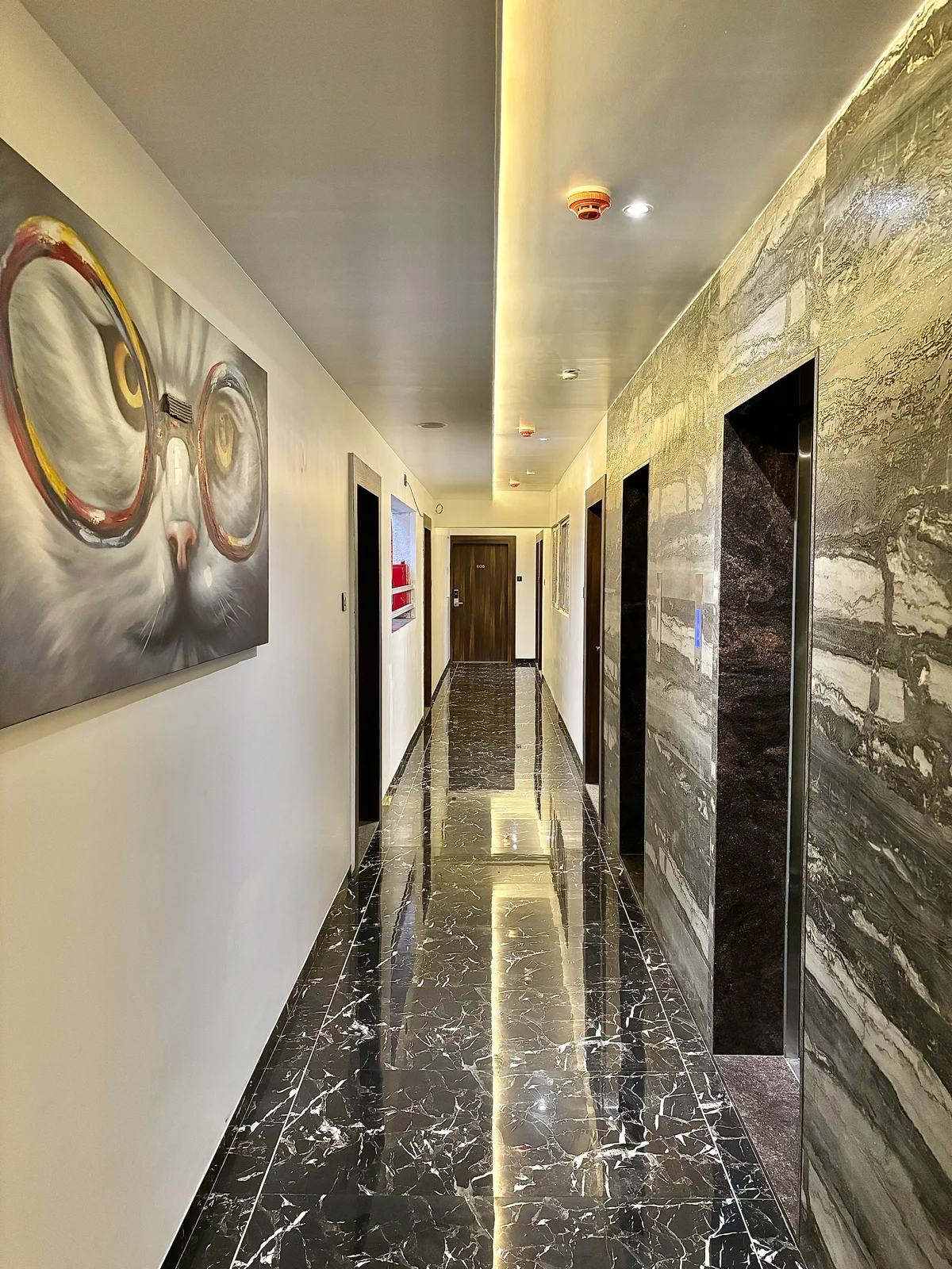 Hotel corridor with marble floors and wall art