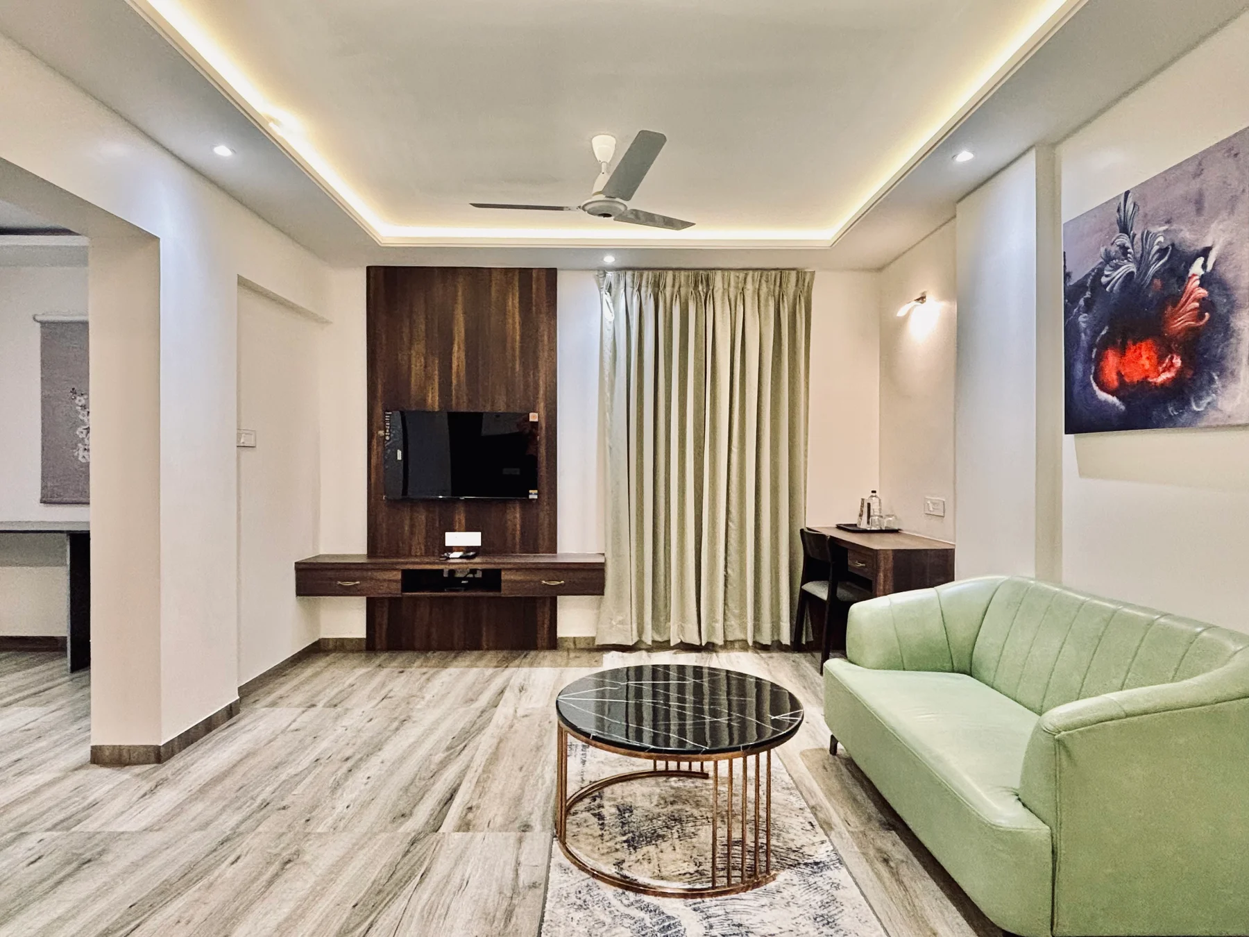Room lounge with green sofa, coffee table and work desk
