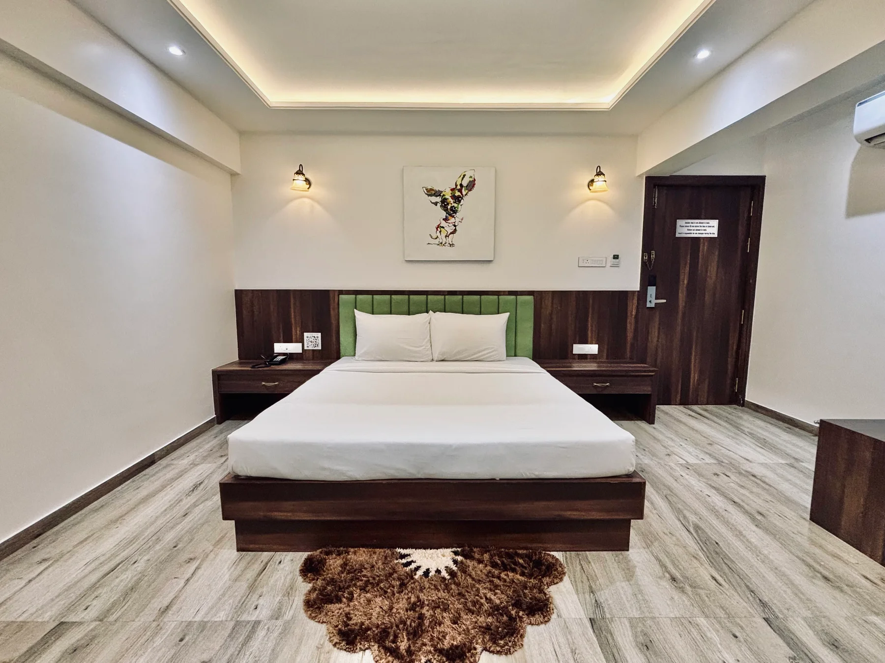 Suite room with a green upholstered headboard and bedside tables