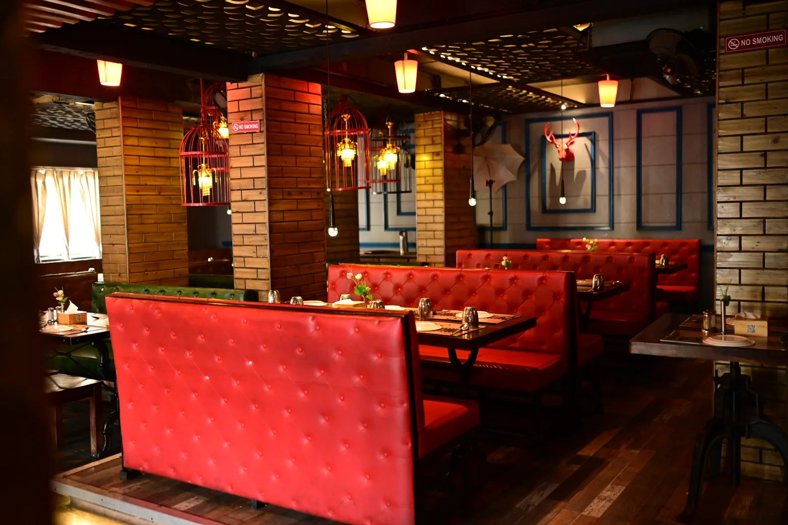 Warmly lit dining area with red booths at RK’s Family Restro
